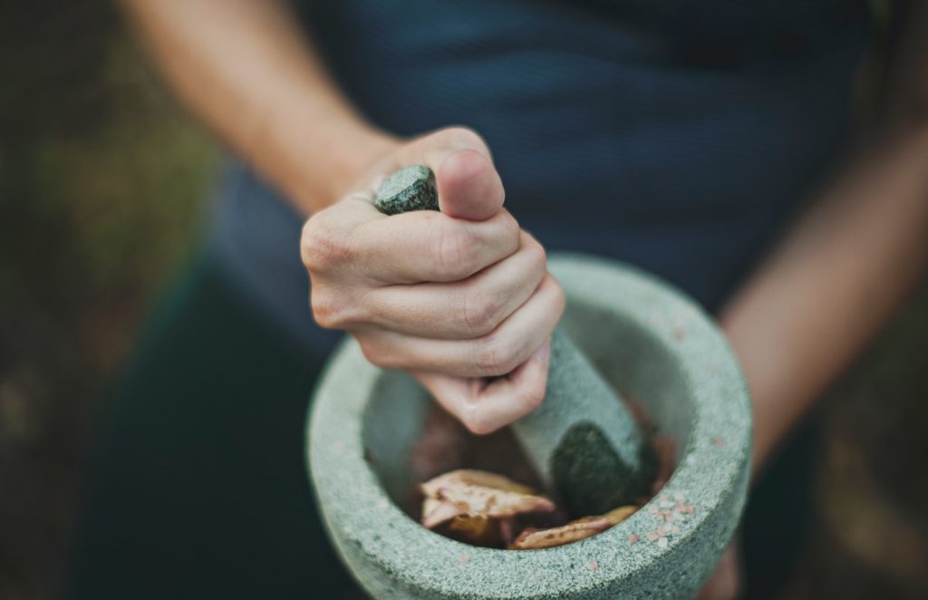 Photo by Lawrence Aritao person grinding on mortar and pestle